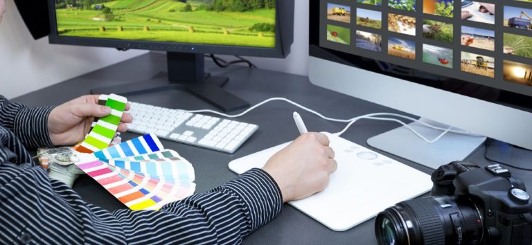 Trabajando en diseño gráfico con paleta de colores y ordenador en un entorno creativo.